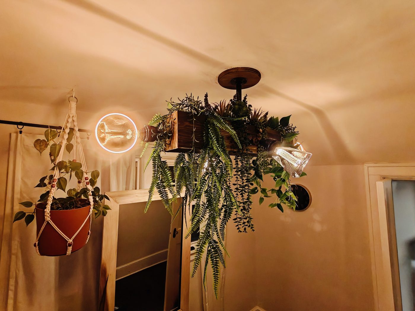 Custom-built timber ceiling light fixture with hanging greenery