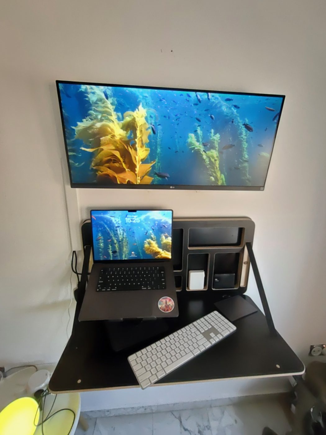 Wall-mounted floating desk with an ultrawide monitor mounted above it